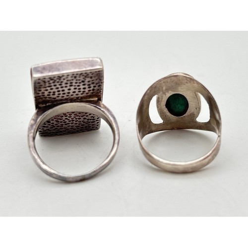 1039 - 2 contemporary design silver rings. A square wood set ring with abstract circular silver overlay, to... 