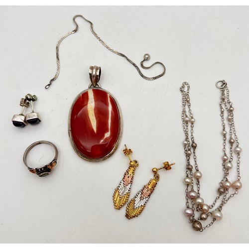 1055 - A collection of silver and white metal jewellery. To include a large oval Mookite jasper pendant, a ... 
