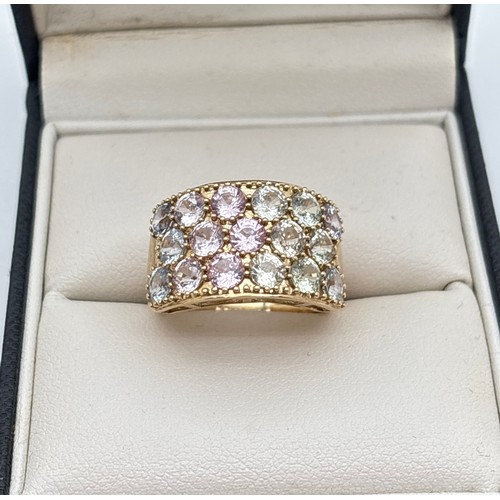 1001 - A 9ct gold wide band half eternity style ring set with a pastel rainbow spectrum of round cut spinel... 