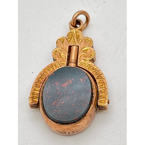 A Victorian 10ct gold swivel pocket watch key fob, set with bloodstone and white agate. Oval fob which swivels to use the key, held in a fan shaped mount with foliate engraved pattern to both sides. Fob mount stamped 10ct. Approx. 4.5cm long. Total weight approx. 9.2g.