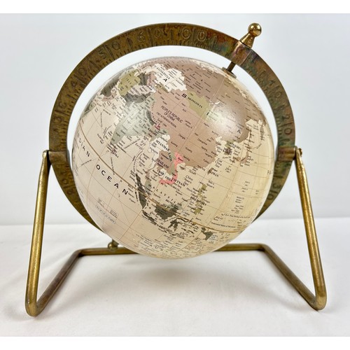 A rotating desk-top globe, held within a brass stand. Latitude and ...
