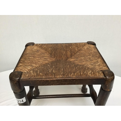 214 - OAK STRETCHERED LANCASHIRE FOOTSTOOL ON PAD FOOT