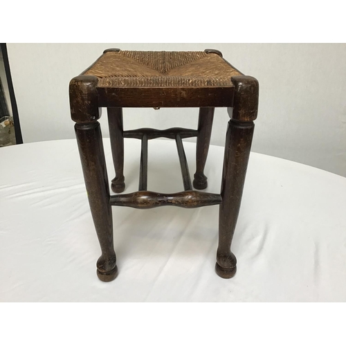 214 - OAK STRETCHERED LANCASHIRE FOOTSTOOL ON PAD FOOT