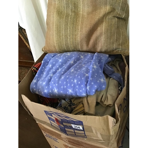 254 - 4 BOXES OF VARIOUS BLANKETS CLOTHES CUSHIONS ETC