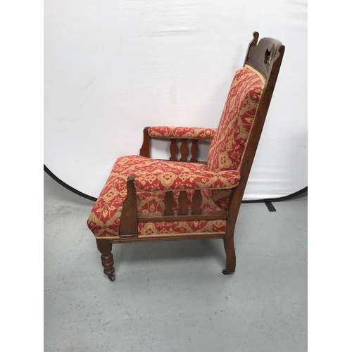 351 - EDWARDIAN OAK UPHOLSTERED ARMCHAIR ON TURNED LEGS AND ORIGINAL CASTORS