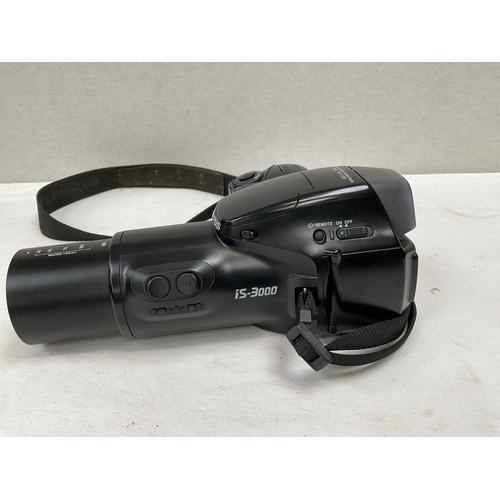 175 - PAIR OF CASED BINOCULARS AND AN OLYMPUS IS-3000 CAMERA AND LENS