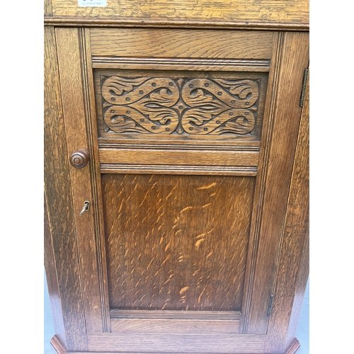 304 - OAK CARVED CORNER CABINET WITH SINGLE DOOR WITH CARVED PANEL COMPLETE WITH KEY - H29