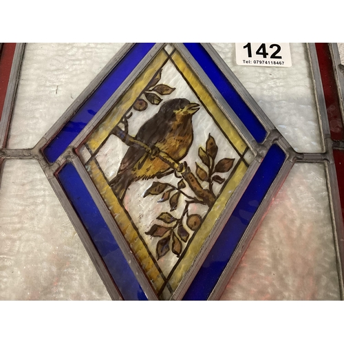 142 - 2 DECORATIVE TILES AND A STAINED GLASS PANEL DECORATED WITH BIRD AND FOILAGE
WINDOW 11