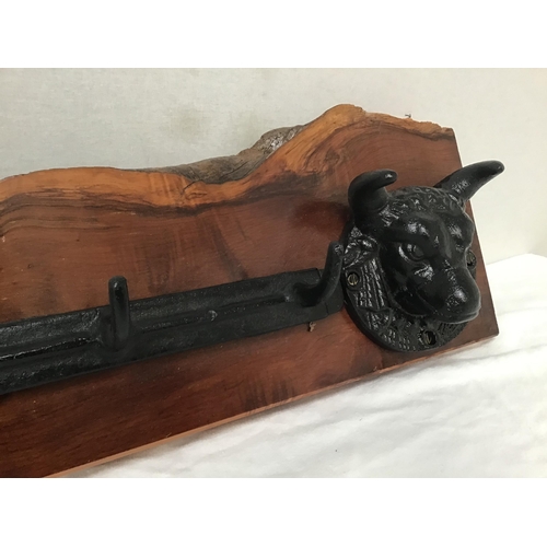 116 - YEW WOOD COAT RACK WITH CAST IRON COAT HOOKS FLANKED BY 2 BULLS HEADS W41