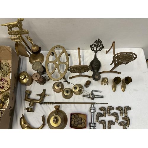 202 - BOX OF BRASSWARE TO INCLUDE BRASS TAPS TRIVETS BELLS FIRE DOGS AND EARLY CAST METAL LAMP