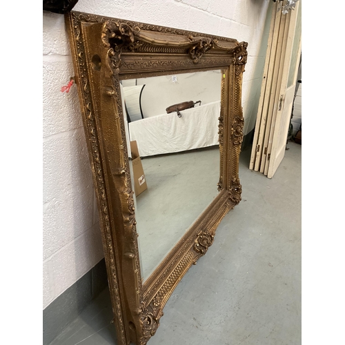 207 - REPRODUCTION ORNATE GILT FRAMED BEVEL EDGE WALL MIRROR OF LARGE PROPORTIONS - 51 X 62