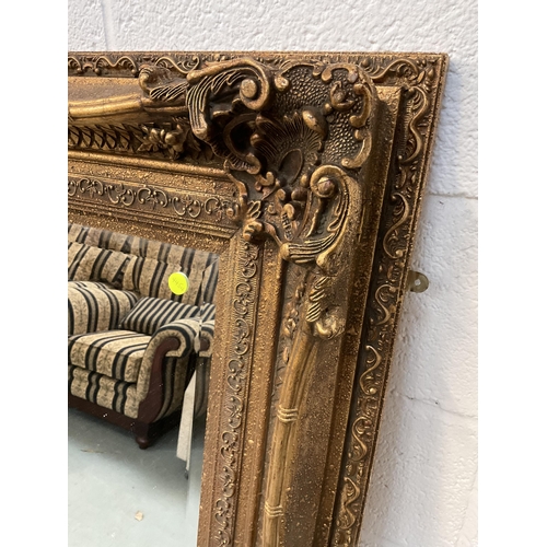 207 - REPRODUCTION ORNATE GILT FRAMED BEVEL EDGE WALL MIRROR OF LARGE PROPORTIONS - 51 X 62