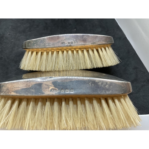 135 - PAIR OF HALLMARK SILVER CLOTHES BRUSHES ALONG WITH A PLATED CANDLE STICK AND A CRUMB TRAY