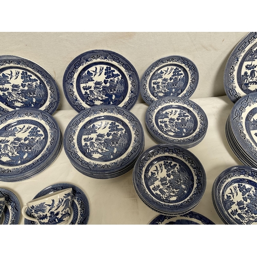 32 - CRATE OF WILLOW PATTERN CHINA TO INCLUDE DINNER PLATES, SIDE PLATES, DESSERT BOWLS, CUPS AND SAUCERS... 