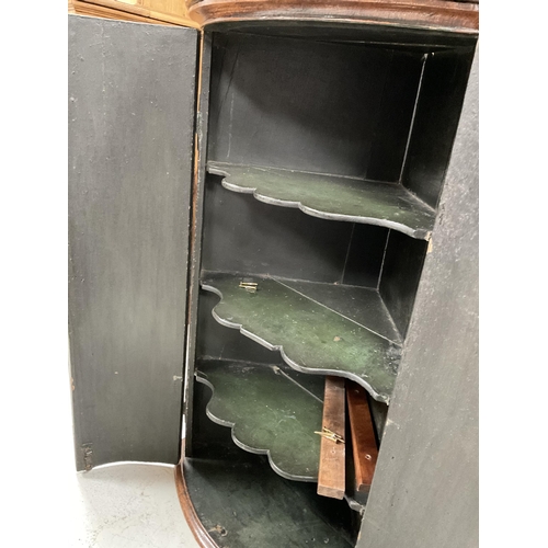 276 - EARLY GEORGIAN OAK WITH MAHOGANY CROSS BANDING BOW FRONT CORNER CABINET WITH BRASS H HINGES AND SHAP... 