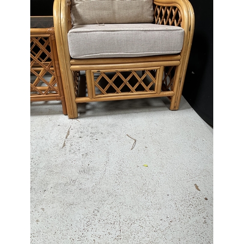 312 - PAIR OF CANE CONSERVATORY CHAIRS AND MATCHING GLASS TOPPED COFFEE TABLE