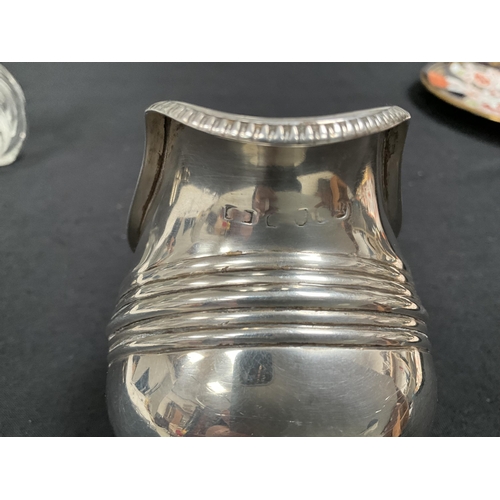 205 - HALLMARK SILVER CREAM JUG, 2 NAPKIN RINGS, COLLARED SCENT BOTTLE 
APPROX TOTAL WEIGHT 155G