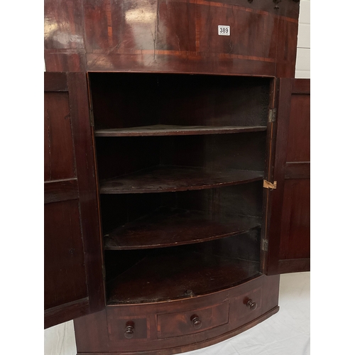 389 - GEORGIAN MAHOGANY INLAID BOW FRONTED HANGING CORNER CABINET WIHT DRAWER TO BASE FITTED WITH SHELVES ... 