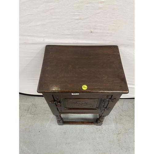 391 - DARK OAK PRIORY STYLE POT CUPBOARD WITH SINGLE DOOR WITH CARVED PANEL ON TURNED AND STRETCHERED BASE... 