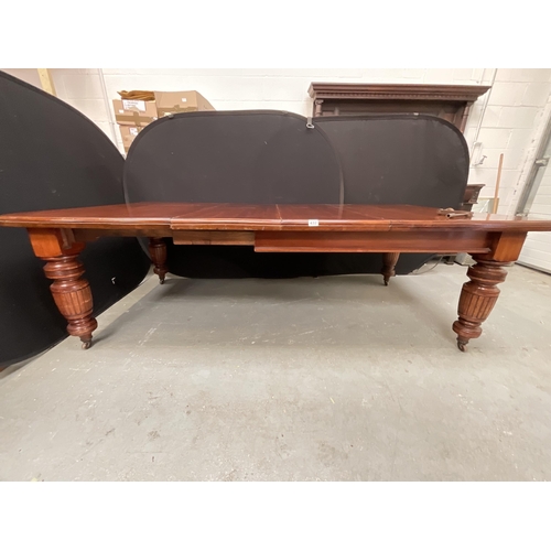 432 - EDWARDIAN MAHOGANY WIND OUT TABLE WITH 2 EXTRA LEAVES ON TURNED AND REEDED LEGS WITH ORIGINAL CASTOR... 