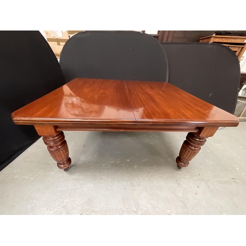 432 - EDWARDIAN MAHOGANY WIND OUT TABLE WITH 2 EXTRA LEAVES ON TURNED AND REEDED LEGS WITH ORIGINAL CASTOR... 