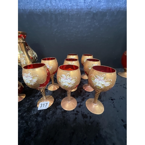 317 - COLLECTION OF GILT OVERLAY RED GLASSWARE TO INCLUDE GOBLETS VASES, WINE DECANTER ETC (JUG H16