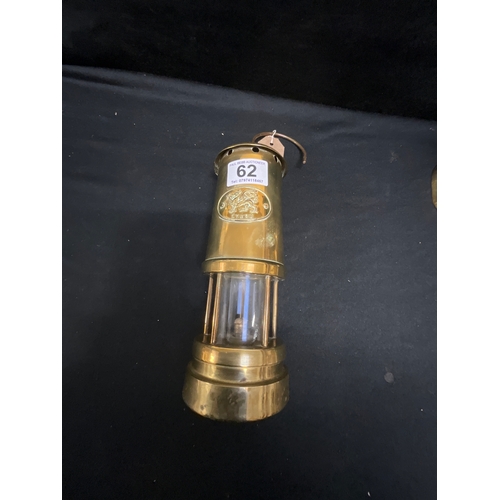 62 - BRASS MINERS LAMP AND A PAIR OF BRASS CANDLE STICKS