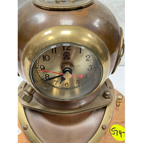 6 - COPPER AND BRASS DIVERS HELMET MANTLE CLOCK (BATTERY) MOUNTED ON WOODEN BASE H8” W10” D6”