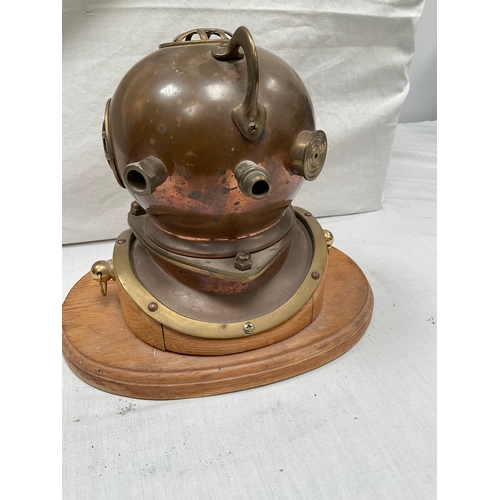 6 - COPPER AND BRASS DIVERS HELMET MANTLE CLOCK (BATTERY) MOUNTED ON WOODEN BASE H8” W10” D6”