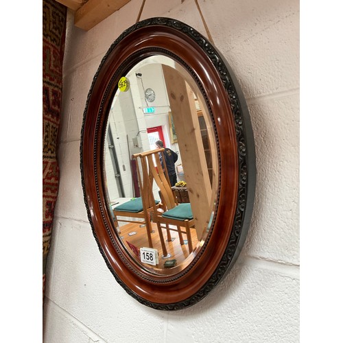 158 - EDWARDIAN MAHOGANY OVAL WALL MIRROR WITH CARVED DECORATION 18” x 15”