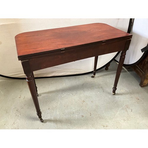 403 - GEORGIAN MAHOGANY FOLDING TEA TABLE ON TURNED LEGS AND ORIGINAL BRASS CASTORS 
H29” W36” D18”