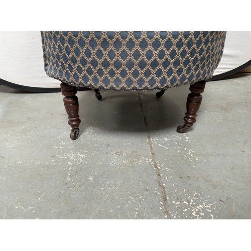 437 - EDWARDIAN UPHOLSTERED TUB CHAIR ON TURNED MAHOGANY LEGS WITH ORIGINAL CHINA CASTORS