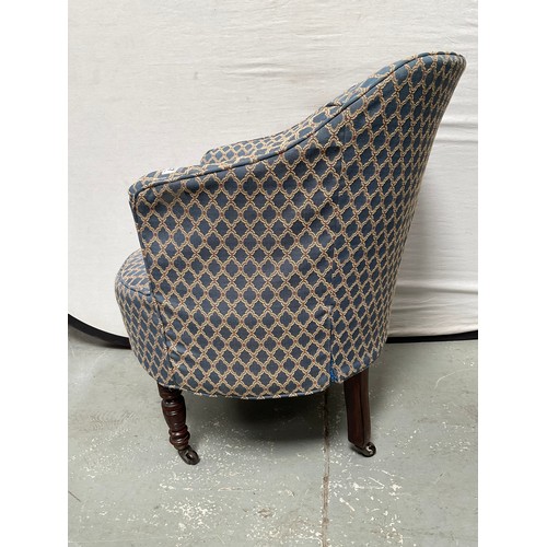 437 - EDWARDIAN UPHOLSTERED TUB CHAIR ON TURNED MAHOGANY LEGS WITH ORIGINAL CHINA CASTORS