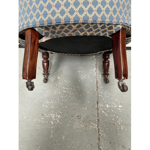 437 - EDWARDIAN UPHOLSTERED TUB CHAIR ON TURNED MAHOGANY LEGS WITH ORIGINAL CHINA CASTORS