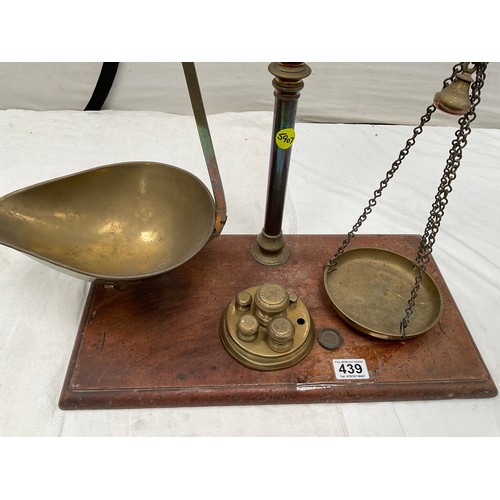 439 - VICTORIAN BRASS BALANCE SCALES COMPLETE WITH WEIGHTS AND TRAYS MOUNTED ON A MAHOGANY PLINTH 
H23” W2... 