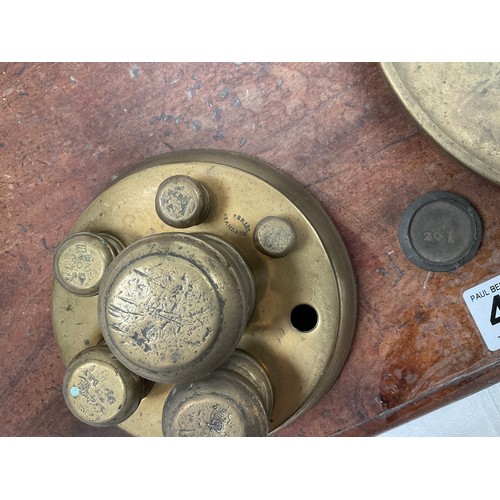 439 - VICTORIAN BRASS BALANCE SCALES COMPLETE WITH WEIGHTS AND TRAYS MOUNTED ON A MAHOGANY PLINTH 
H23” W2... 