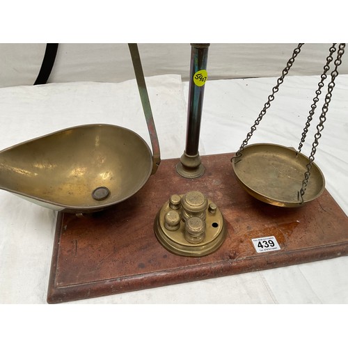 439 - VICTORIAN BRASS BALANCE SCALES COMPLETE WITH WEIGHTS AND TRAYS MOUNTED ON A MAHOGANY PLINTH 
H23” W2... 