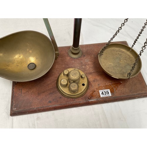 439 - VICTORIAN BRASS BALANCE SCALES COMPLETE WITH WEIGHTS AND TRAYS MOUNTED ON A MAHOGANY PLINTH 
H23” W2... 