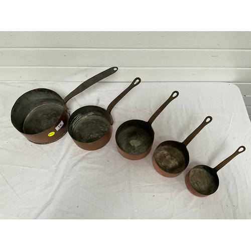 16 - A SET OF FIVE GRADUATED COPPER SAUCEPANS