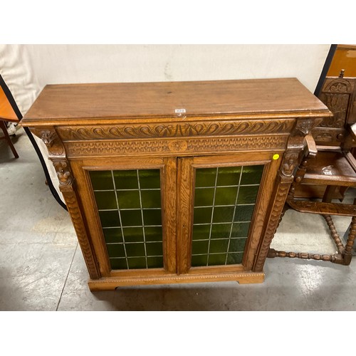 429 - EDWARDIAN CARVED OAK GOTHIC STYLE TWO DOOR BOOK CASE WITH GREEN GLASS PANELS W46
