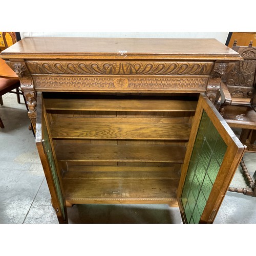 429 - EDWARDIAN CARVED OAK GOTHIC STYLE TWO DOOR BOOK CASE WITH GREEN GLASS PANELS W46