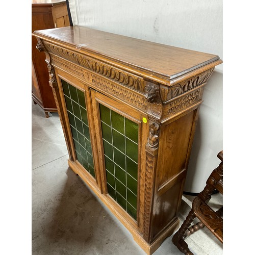 429 - EDWARDIAN CARVED OAK GOTHIC STYLE TWO DOOR BOOK CASE WITH GREEN GLASS PANELS W46