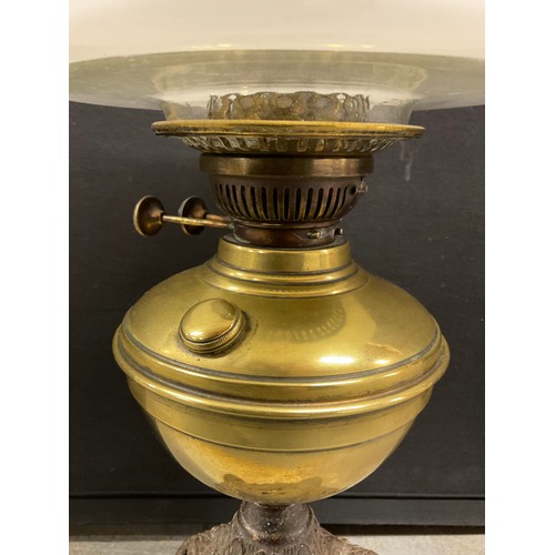 25 - ANTQIUE CAST IRON AND BRASS OIL LAMP WITH A WHITE GLASS SHADE COMPLETE WITH FUNNEL H 23”