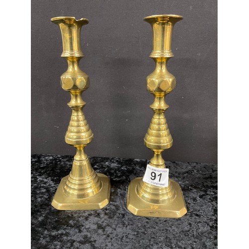 91 - TWO PAIRS OF ANTIQUE BRASS CANDLESTICKS WITH PUSHERS