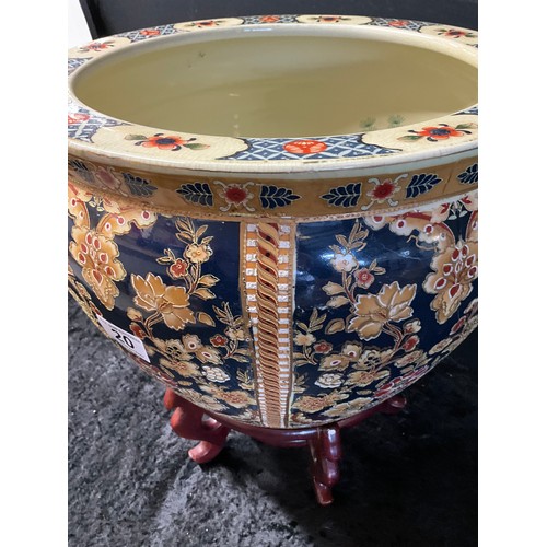 20 - LARGE MODERN ORNATE CERAMIC JARDINERE WITH GILT WORK FLOWERS AND ORNATE FISH INTERIOR ON A WOODEN PL... 