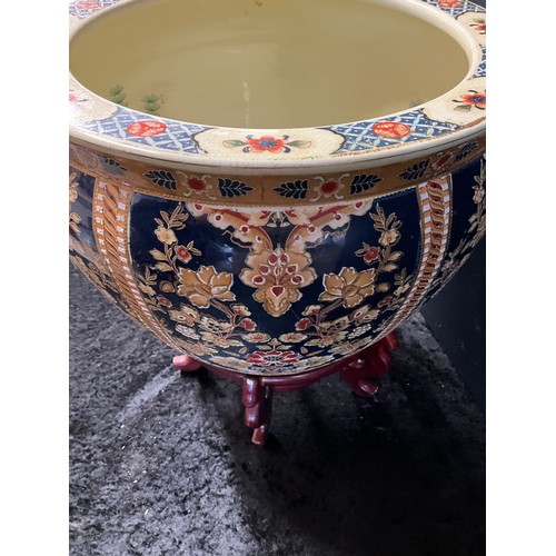 20 - LARGE MODERN ORNATE CERAMIC JARDINERE WITH GILT WORK FLOWERS AND ORNATE FISH INTERIOR ON A WOODEN PL... 