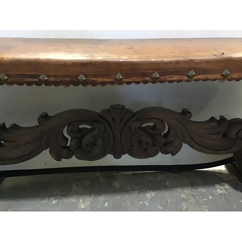 542 - ANTIQUE CARVED OAK BENCH WITH UPHOLSTERED LEATHER TOP AND ORNATE CARVING TO BASE W50