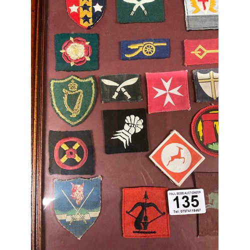 135 - FRAMED COLLECTION OF MILITARY CLOTH PATCHES 26” X 18”