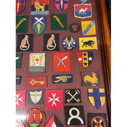 135 - FRAMED COLLECTION OF MILITARY CLOTH PATCHES 26” X 18”