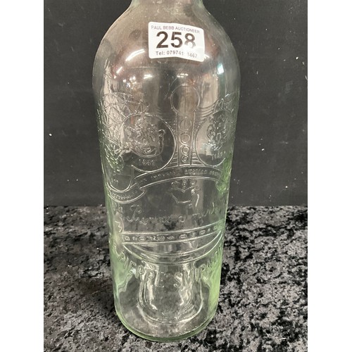 258 - LARGE SMIRNOFF EMBOSSED GLASS BOTTLE AND ONE OTHER